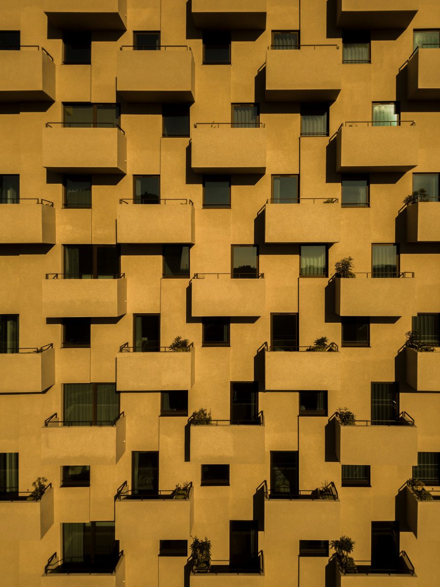 Věž je nápadná svou fasádou, která drží přísný geometrický rastr. (Tower 15 v Leça da Palmeira v Portugalsku, OODA)