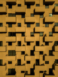 Věž je nápadná svou fasádou, která drží přísný geometrický rastr. (Tower 15 v Leça da Palmeira v Portugalsku, OODA)