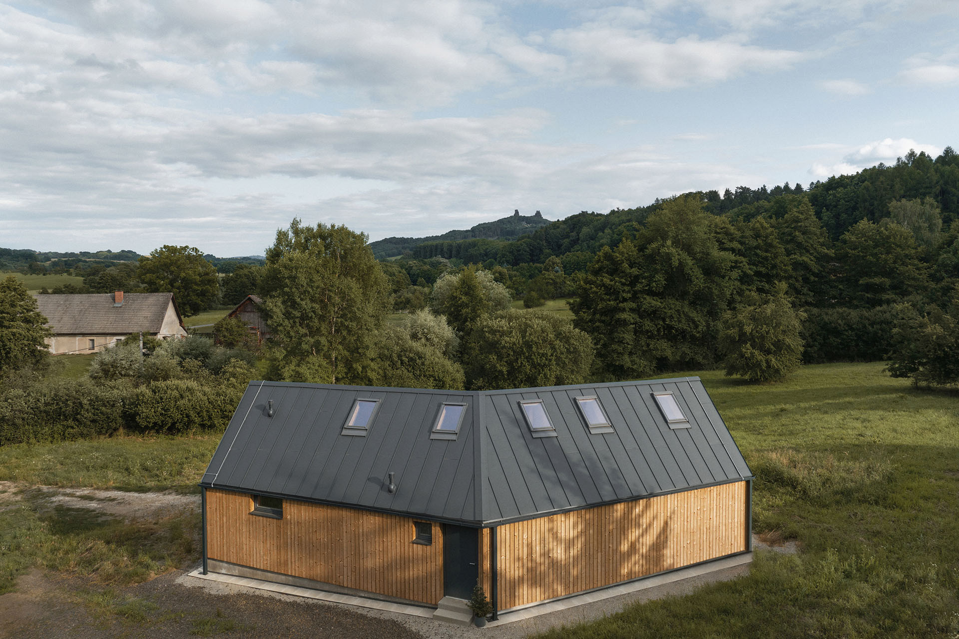 Ze severu je příjezdová komunikace. Na tuto stranu má dům jen několik otvorů. (Víkendový dům v Českém ráji, NEW HOW Architekti)