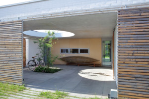 Když se vrata rozevřou, otevře se průhled do zastřešeného atria.  (Rodinný dům Polanka nad Odrou; bydloarchitekti)