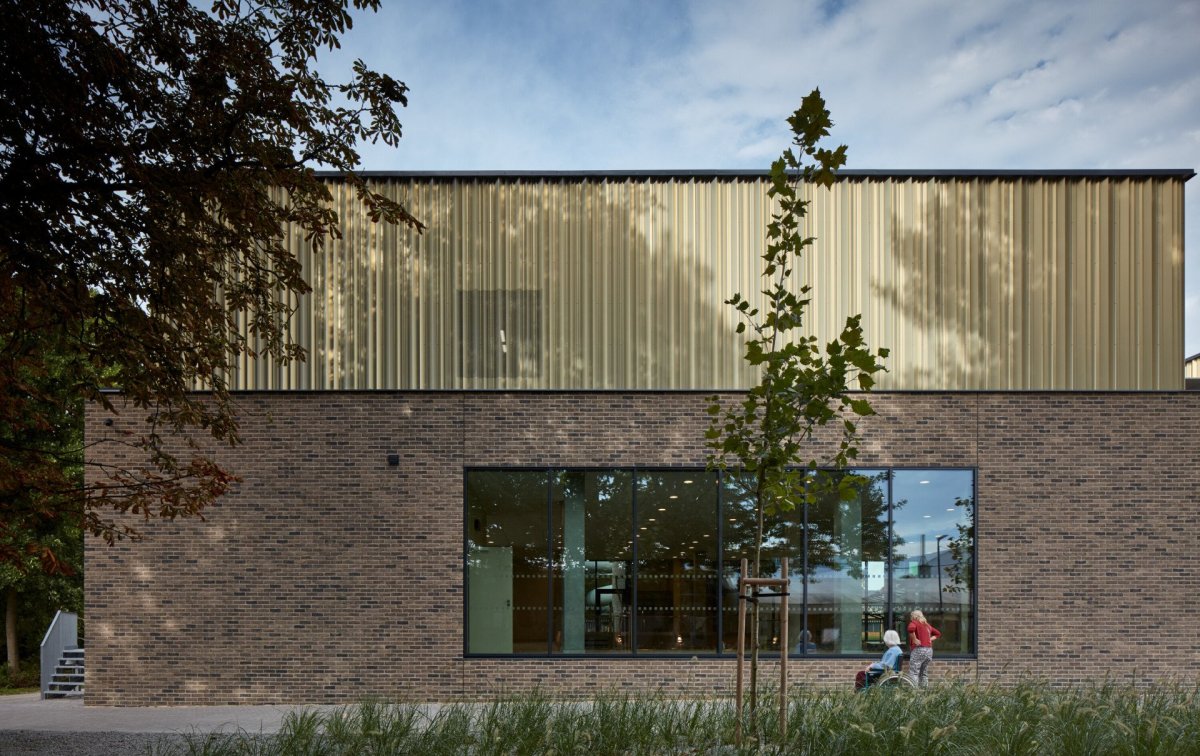 Aquavparku v Kyjově, SENAA architekti: Bazénová hala je proto hmotově rozdrobená. Parter je pevný, tvoří ho táhlá stěna obložená cihelnými pásky.