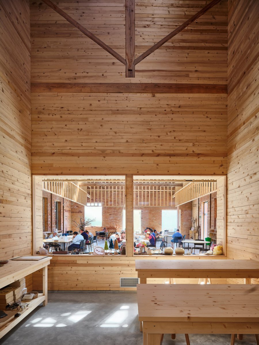Jednotlivé místnosti jsou odděleny příčkou s průhledy. (Sociální projekt v bývalé textilní továrně; H ARQUITECTES)