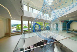 Umělecká instalace ze světle modrých poloprůhledných skleněných koulí prostupuje všemi třemi podlažími a doplňuje otevřený a transparentní design Dětského centra Bethel.