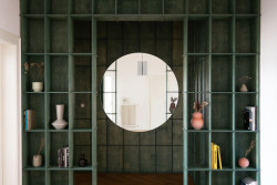 Výrazné zelené zádveří s kruhovým zrcadlem je bránou do bytu. (rekonstrukce prvorepublikového bytu v Bubenči, Studio COSMO)