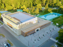 Bazén se nachází na předělu města a přírody a přiléhá k němu ještě venkovní koupaliště