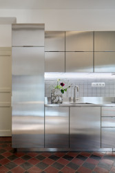 Byt Nusle, Amulet + T. Melková: Díky svému materiálu kuchyňská linka částečně zrcadlí okolí a světlo, čímž kuchyni bez okna opticky zesvětluje.