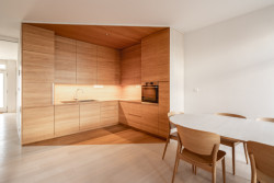 Kuchyně a jídelní stůl se zaoblenými rohy. (Interiér domu Ke Káčatům v Brně, studio AEIOU)