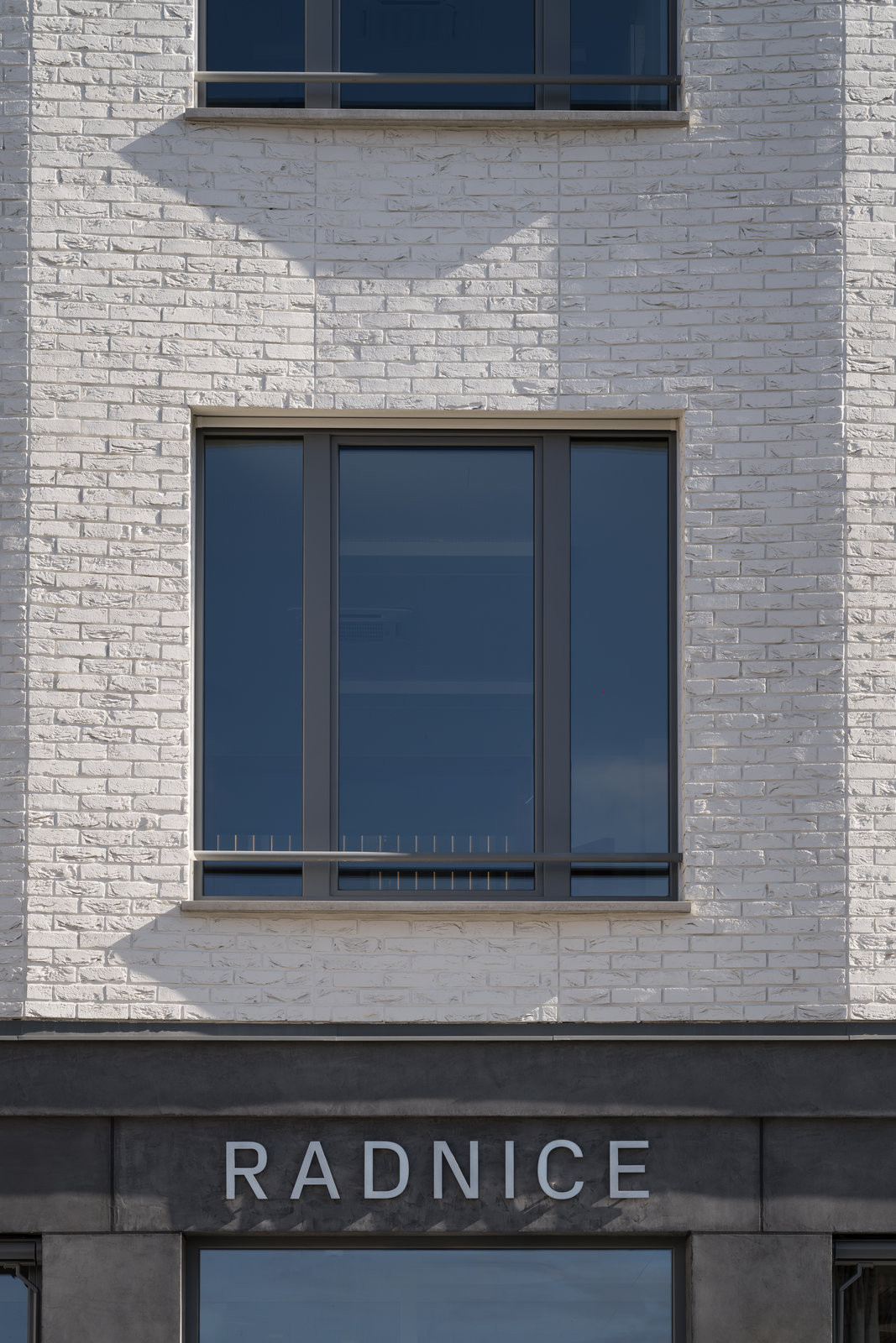 Detail bílých cihlových pásků – utlumený
materiálový výraz zvýrazňuje plasticitu fasády. (Nová radnice s plastickou fasádou; re:architekti)