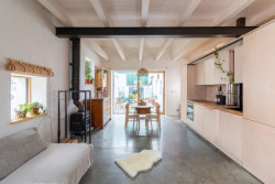 Obývací pokoj s kuchyní se do dvorku otevírá prosklenou stěnou. (Rodinný dům v Kohoutovicích, Ateliér Kopecký)