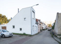 Původně to byl řadový dům, poznat je to z jeho dlouhé boční stěny, která se odhalila po zbourání souseda. (Rodinný dům v Kohoutovicích, Ateliér Kopecký)