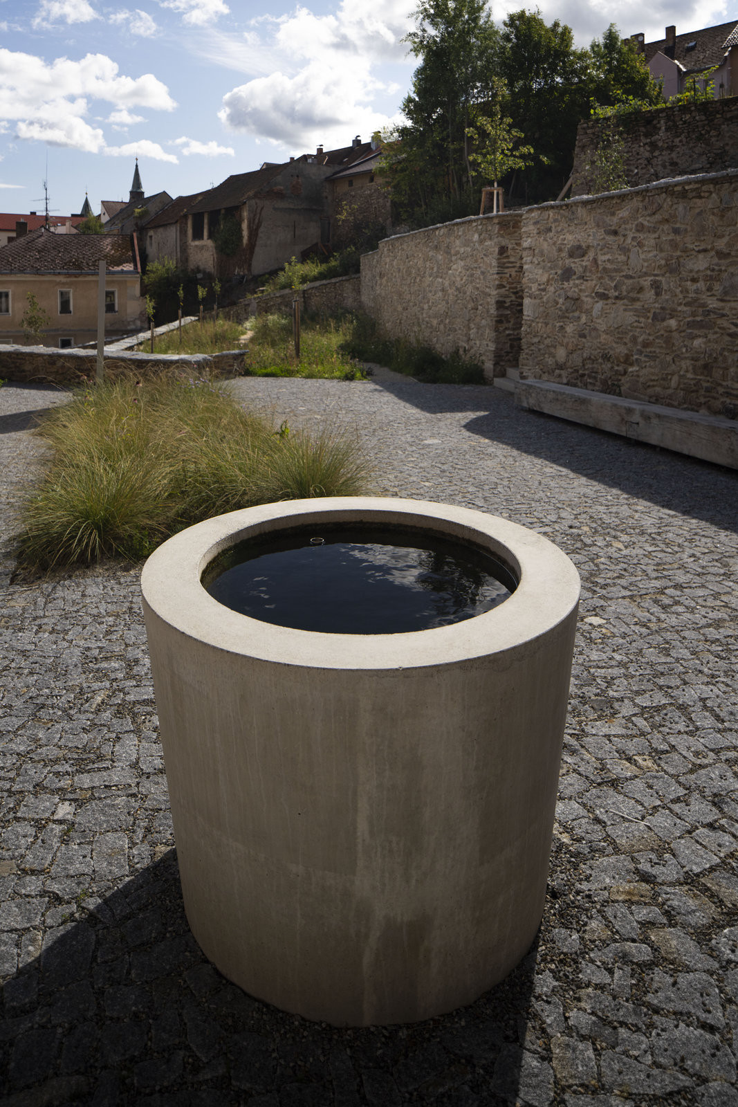 Fontána v zákoutí budovy pivovaru využívá akumulovanou dešťovou vodu z teras. (Pivovarské terasy; Steiner a Malíková krajinářští architekti, Roman Brychta Architekti)
