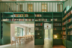 Obývacímu pokoji dominuje zelená knihovna (Rodinný dům Chřibská od 0,5 Studio)