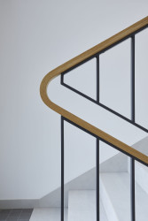 Atypické madlo zábradlí je vyrobeno z ohýbaného dřeva. (Bytový dům Krušec, monom)