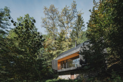 Terasa je chráněná harmonikovou dřevěnou okenicí. (Chata u Sázavy mezi skálou a řekou; Mimosa Architekti)