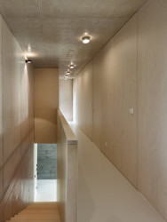 Vila je plná kontrastů - surový beton a teplý dřevěný nábytek. (Vila Troja, Stempel & Tesar architekti)