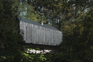 Opálením získala prkna fasády trvanlivost.  (Chata u Sázavy mezi skálou a řekou; Mimosa Architekti)