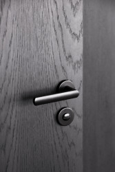 Půdní byt s černým boxem, Komon architekti: Černá olejovaná dýha boxu v obležení bílých stěn a nábytku zřetelně vystupuje a svým minimalistickým zpracováním a absencí detailu nutí pozorovatele zaměřit se na její čisté linie a jasnou texturu dřeva