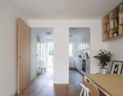 Architekti ji ale udělali prostupnější. Průřezem ve stěně se tudy vchází do kuchyně, která pak navazuje na obývací pokoj. (Bydlení v řadovém domě v Praze-Strašnicích, BY architects)