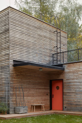 Jemné odkazy na funkcionalismus – červené dveře s kulatými okénky připomínajícími lodní kajutu nebo žebřík vedoucí na střechu. (Dům v Davli, 0,5 Studio)