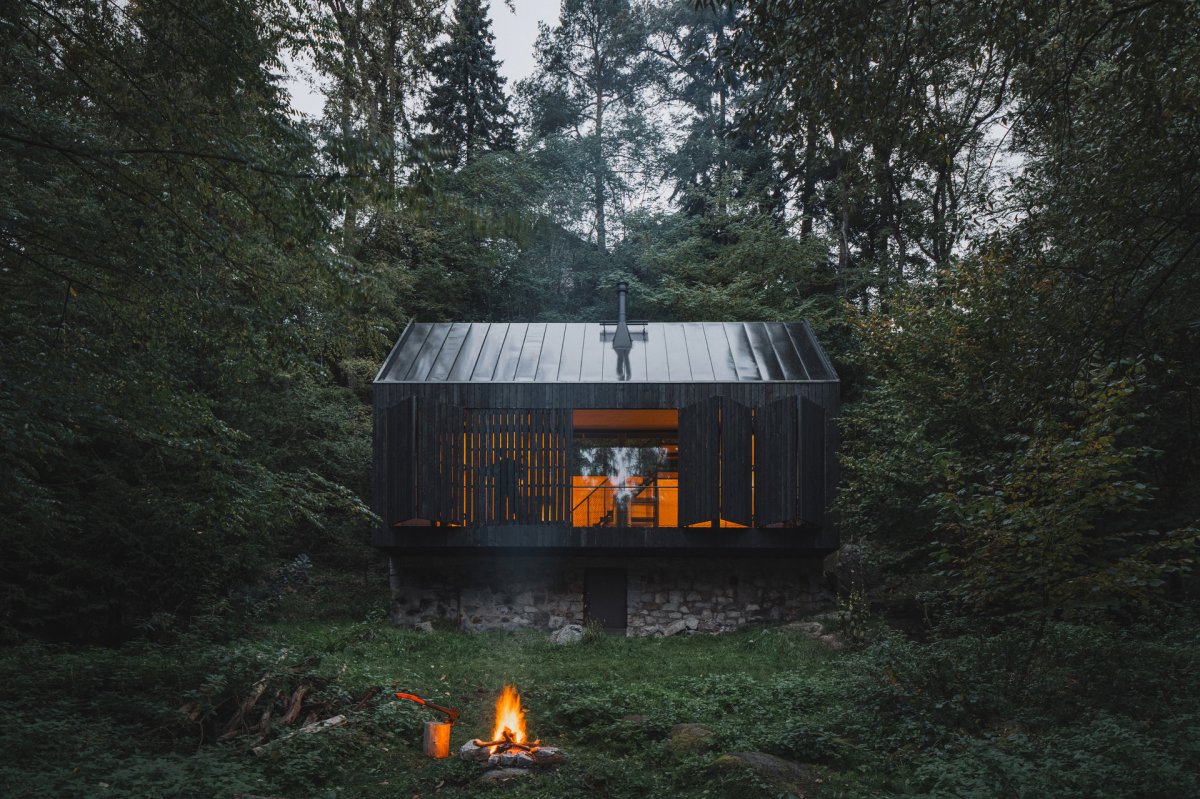 Večerní posezení u ohně podporuje tu pravou chatařskou atmosféru. (Chata u Sázavy mezi skálou a řekou; Mimosa Architekti)