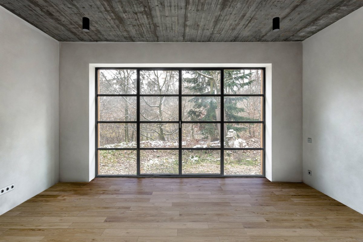 V interiéru se mísí bílá barva se dřevem a betonem. (Chata JARO u Prahy, edit! architects) 