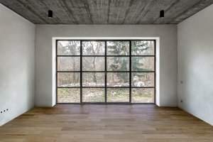 V interiéru se mísí bílá barva se dřevem a betonem. (Chata JARO u Prahy, edit! architects) 