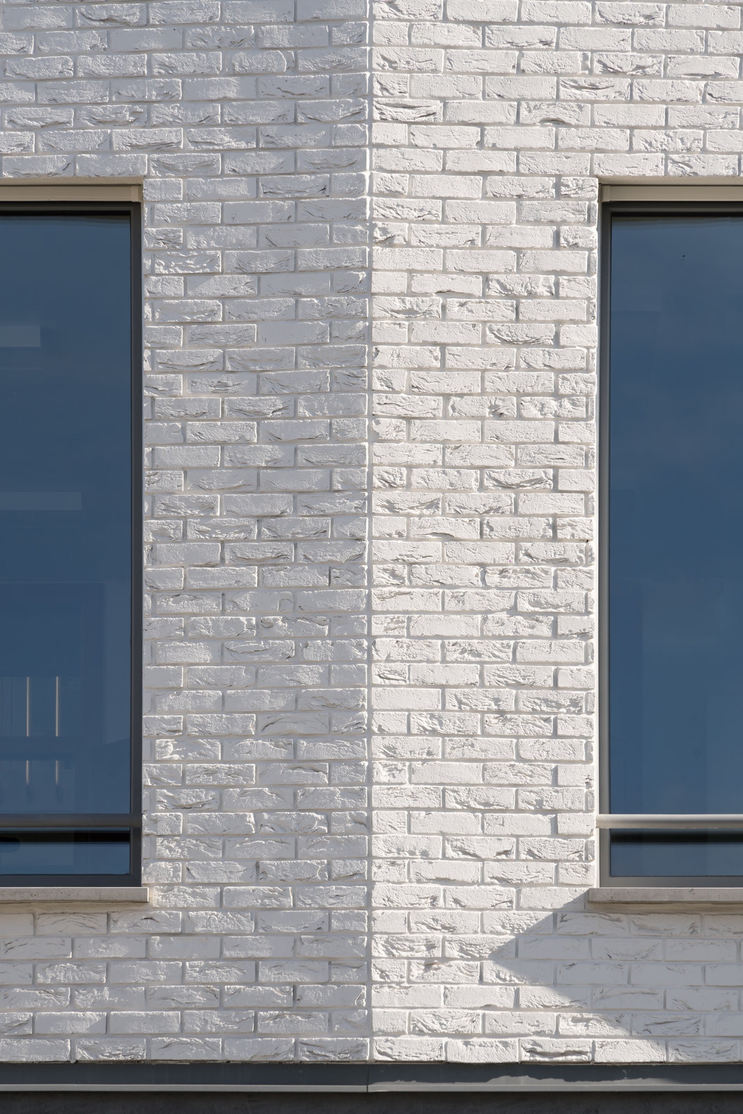 Detail bílých cihlových pásků – utlumený
materiálový výraz zvýrazňuje plasticitu fasády. (Nová radnice s plastickou fasádou; re:architekti)