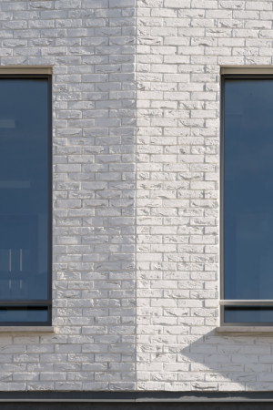 Detail bílých cihlových pásků – utlumený
materiálový výraz zvýrazňuje plasticitu fasády. (Nová radnice s plastickou fasádou; re:architekti)
