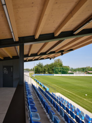 Divácká tribuna je krytá vykonzolovanou dřevěnou střechou, pod kterou je také kabina hlasatele s dobrým výhledem na celé fotbalové hřiště. (Sportovní areál SK Planá, PROAM ARCHITEKTI)