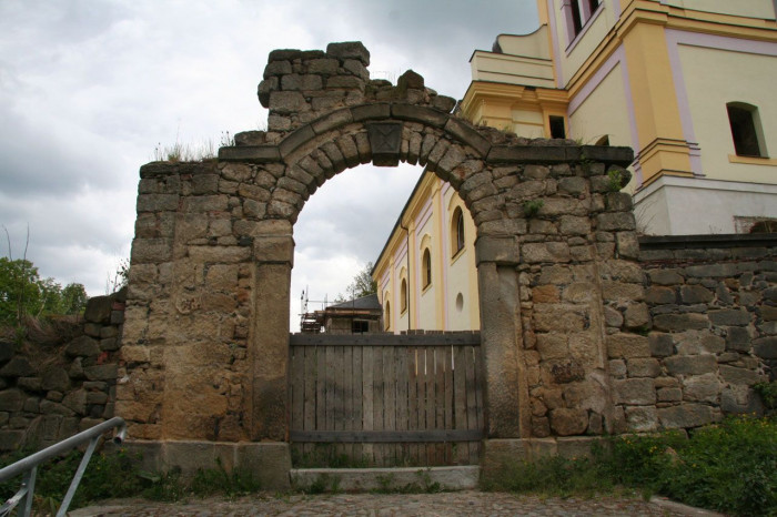 Stav brány v ohradní zdi před rekonstrukcí (2012). Chybějící část brány a její celkový tvar byly odvozeny z historických fotografií - foto