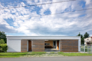 Směrem k ulici se obrací vraty, jezdí po přiznaných pojezdech. (Rodinný dům Polanka nad Odrou; bydloarchitekti)