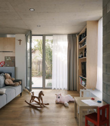 Do hlavního obytného prostoru ústí kuchyň, knihovna, krb a oddělitelné schodiště. (Rodinný dům v Radotíně, Papundekl architekti)