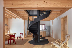 Interiéru dominuje krb, kolem kterého se točí kovové schodiště. 