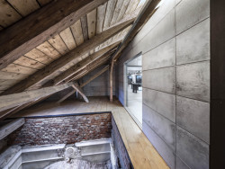 Skrze prosklené plochy betonového objektu lze nahlédnout na vrchní část cihelné klenby nebo na původní krov