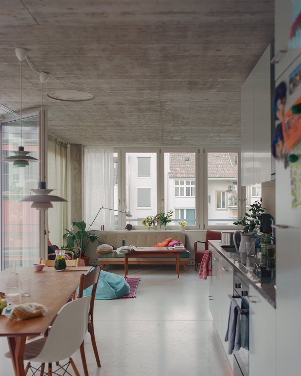 Obývací pokoj s kuchyní má celou prosklenou stěnu s výstupem na balkon. (Komunitní bydlení v bývalé industriální zóně; Clauss Kahl Merz Atelier)
