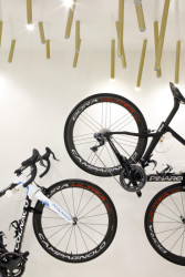 Cyklobutik L27, P6PA+Architects: Lesklý povrch stěn zrcadlí osvětlení v místnosti i kola zavěšená na zdech