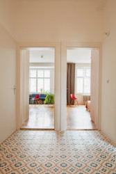 Pohled z chodby směrem k klavnímu obytnému prostoru a ložnici (Rekonstrukce bytu na Letné; 0,5 Studio)