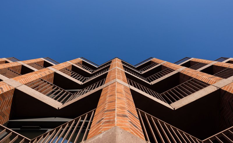 Fasáda budovy staví na promyšlené geometrii a rytmickém uspořádání pilastrů, které lemují lodžie.