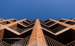 Fasáda budovy staví na promyšlené geometrii a rytmickém uspořádání pilastrů, které lemují lodžie.