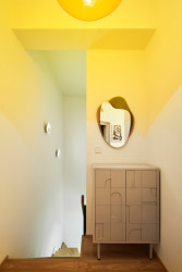 Chodba v patře, prozářená žluto-oranžovou. (Byt na Novém Městě, Helena Ballošová)