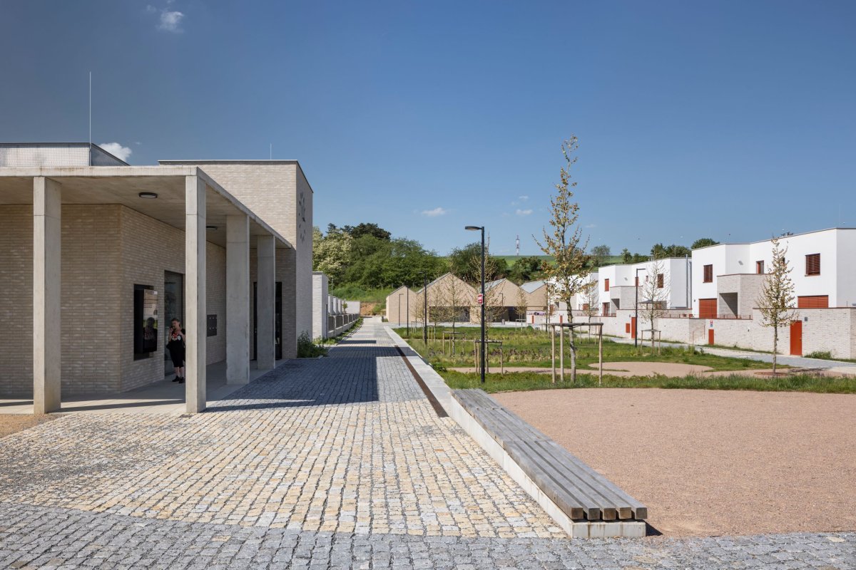 Veřejné budovy mají obklad z režného zdiva, soukromé jsou omítnuté. (Obytný soubor Dolina v Lysolajích, knesl kynčl architekti)