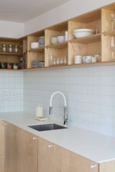 V bytě vládne vybavení z překližky a světlé povrchy s barevnými akcenty. (Byt v paneláku od hurá studio)