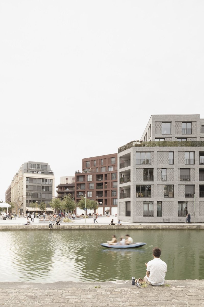 Studio AVENIER CORNEJO architectes navrhlo na břehu kanálu na předměstí Paříže obytný soubor třech domů s různým odstínem lícových cihel