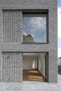 Studio AVENIER CORNEJO architectes navrhlo na břehu kanálu na předměstí Paříže obytný soubor třech domů s různým odstínem lícových cihel