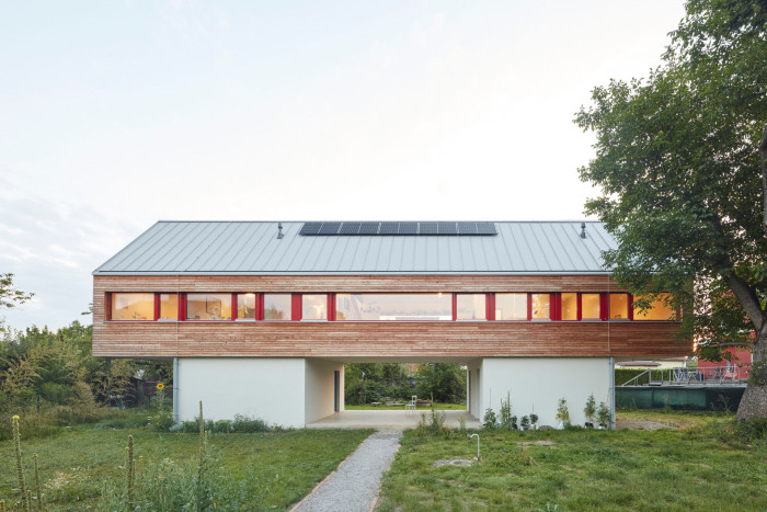 Architekti z 0,5 Studia navrhli dvoupodlažní dřevostavbu, která je vynesena do požadované výšky na dvou betonových podstavách. 