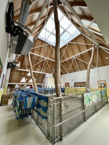 Ve čtvercové bílé hmotě je zázemí, jednotlivé třídy fungují v barevných pagodách. Uvnitř vstupní síně společné všem třídám to vypadá takto - je osvětlené horním světlíkem a na úrovni patra vybavena sítí, ve které by děti mohly běhat, kdyby se jim to nezakázalo. Proč tomu tak je, se dočtete v textu od Karolíny Vránkové u nás na EARCH.cz.