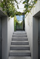 Vstup na nejnižší úrovni domu byl celkově zvětšen a prosvětlen díky proskleným dveřím. (Rekonstrukce domu na Břevnově; Mimosa architekti)