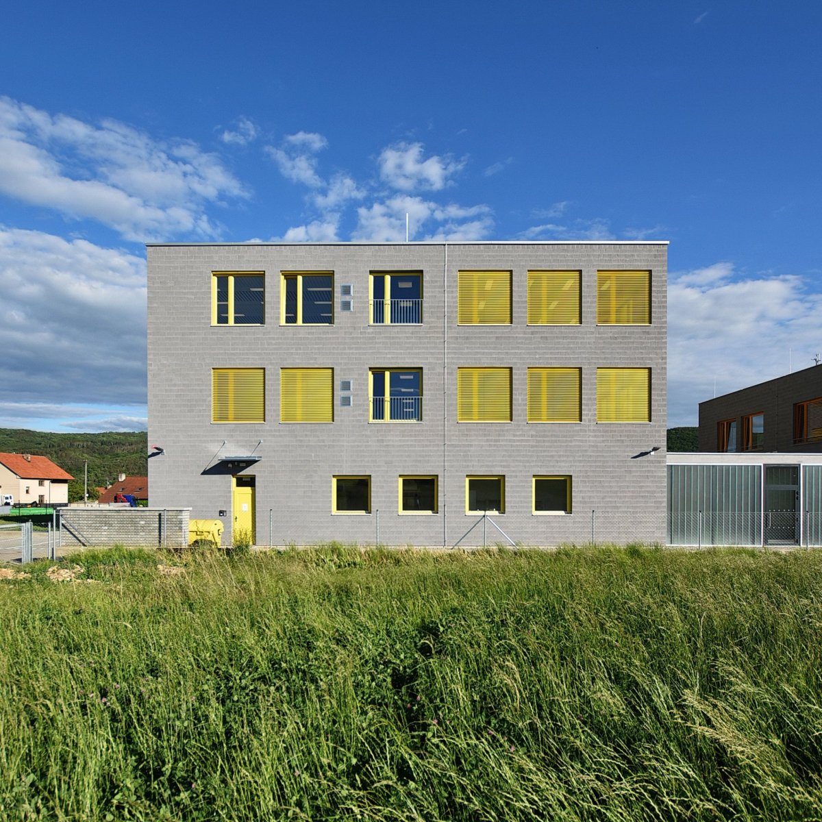 Škola a školka v Letech, Architekt Ondřej Tuček: Oba pavilony stojí na čtvercovém půdoryse, fasády traktují okna v pravidelném rastru.