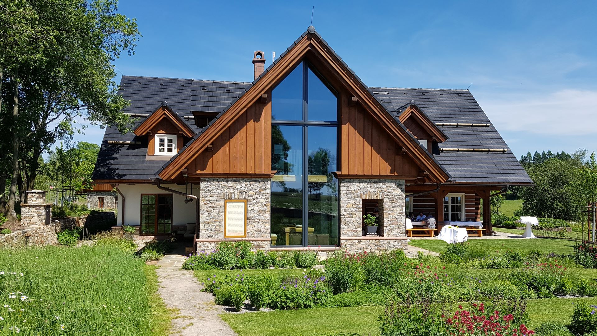 Rozsáhlá prosklená plocha a velká okna v roubence opticky rozšiřují interiér a navozují pocit volnosti.