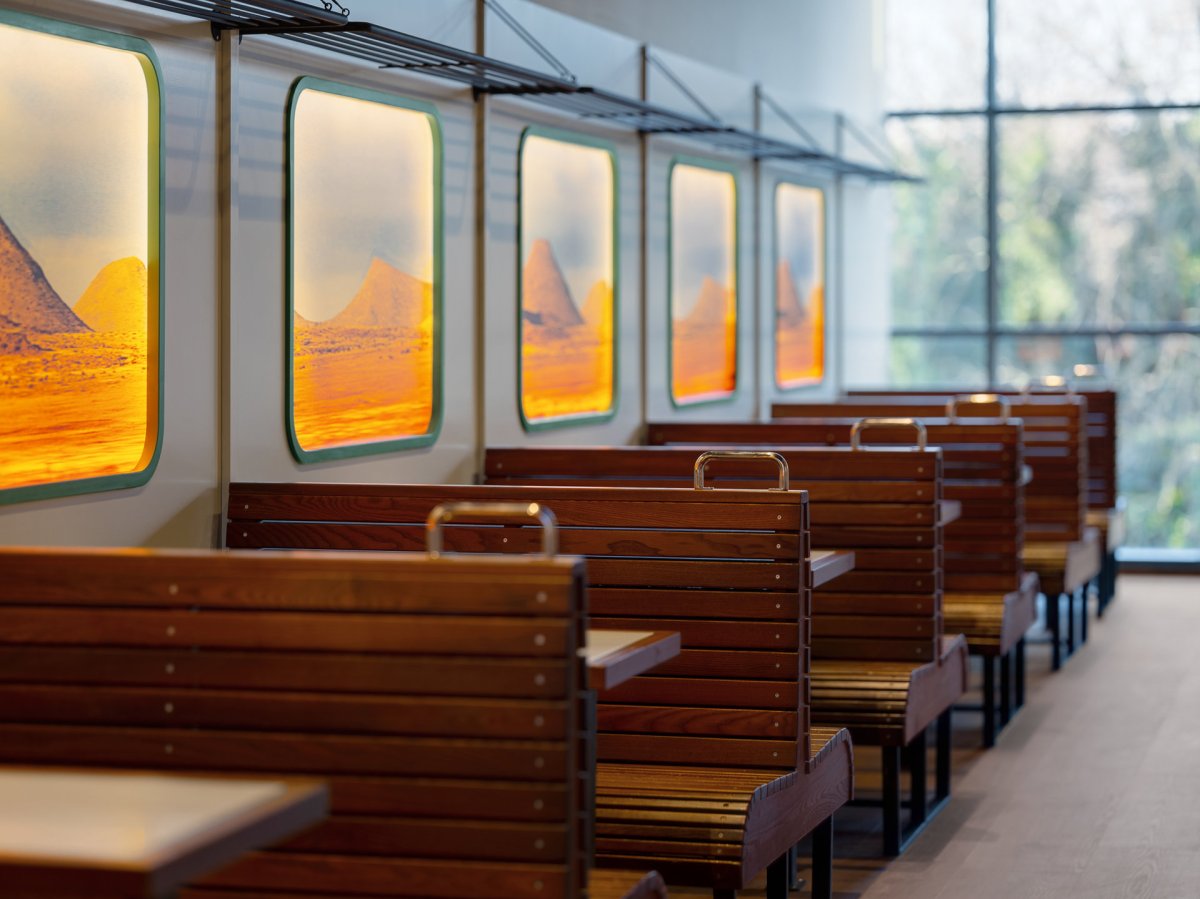 Estetiku indického vlaku umocňují dřevěné lavice i odkládací police nad "okénky". (Bombay Express; Studio archicraft)